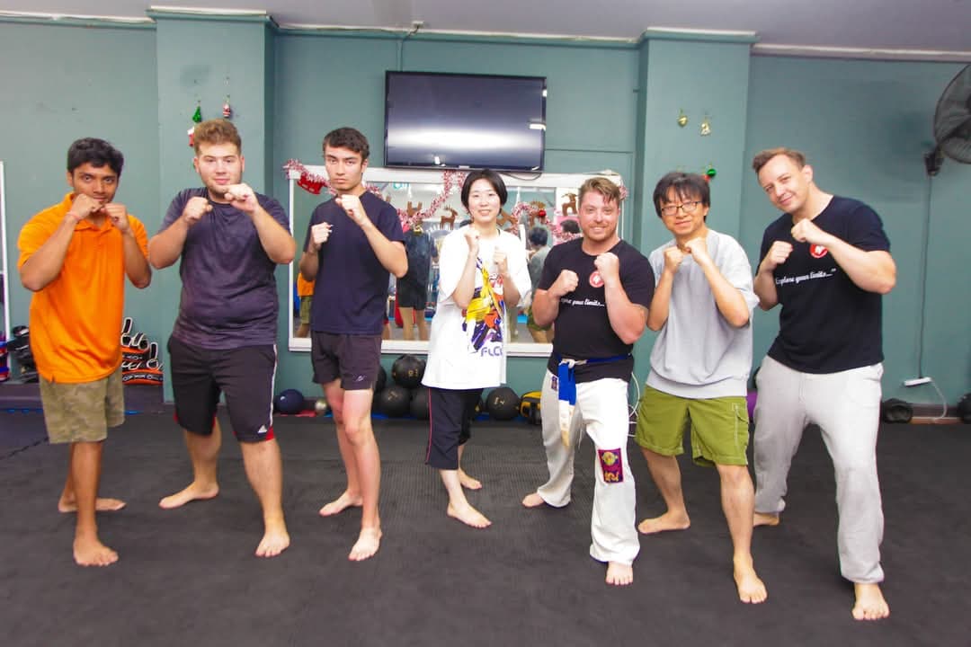 Students and instructors holding a fighting stance together in the gym